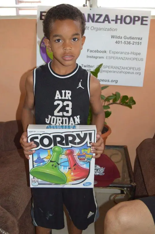 A boy holding a box of the Sorry board game