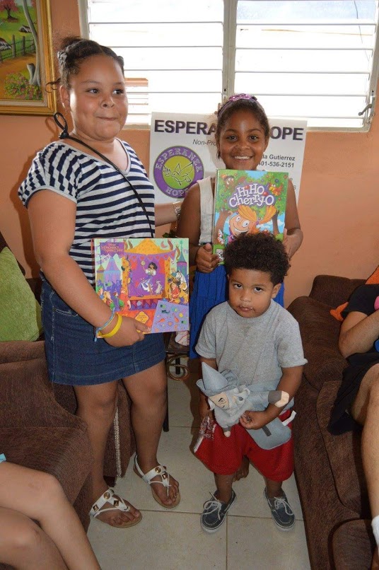 Two girls holding books and a little boy holding a dwarf stuffed toy