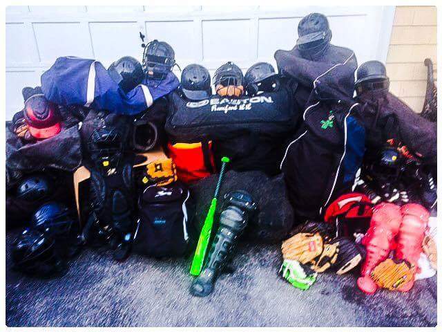 Bags and baseball equipment piled together