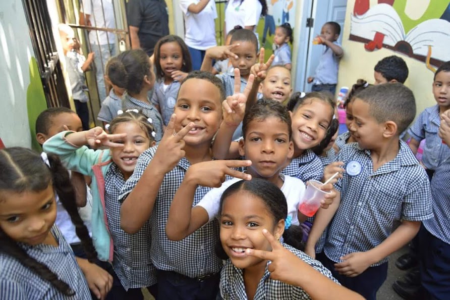 Children smiling and doing peace signs, 2