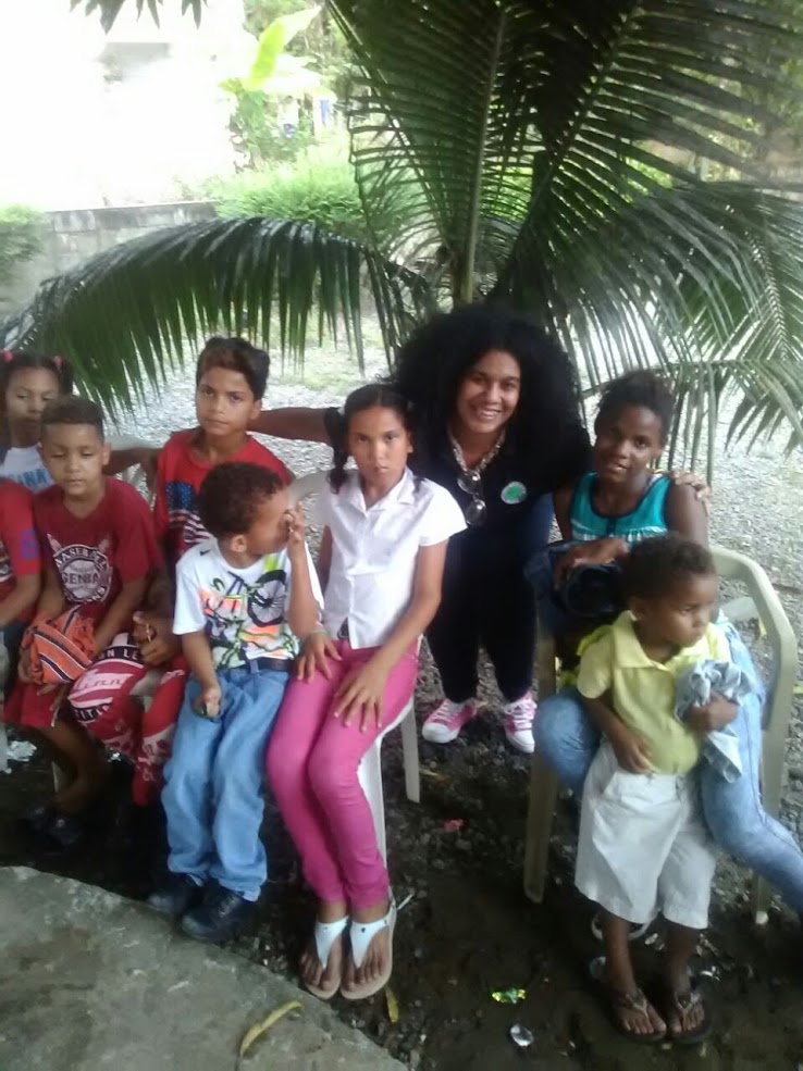 Our staff and children sitting by a small palm tree