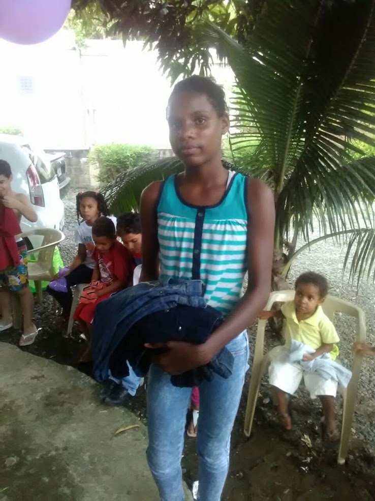 A girl holding several pairs of pants