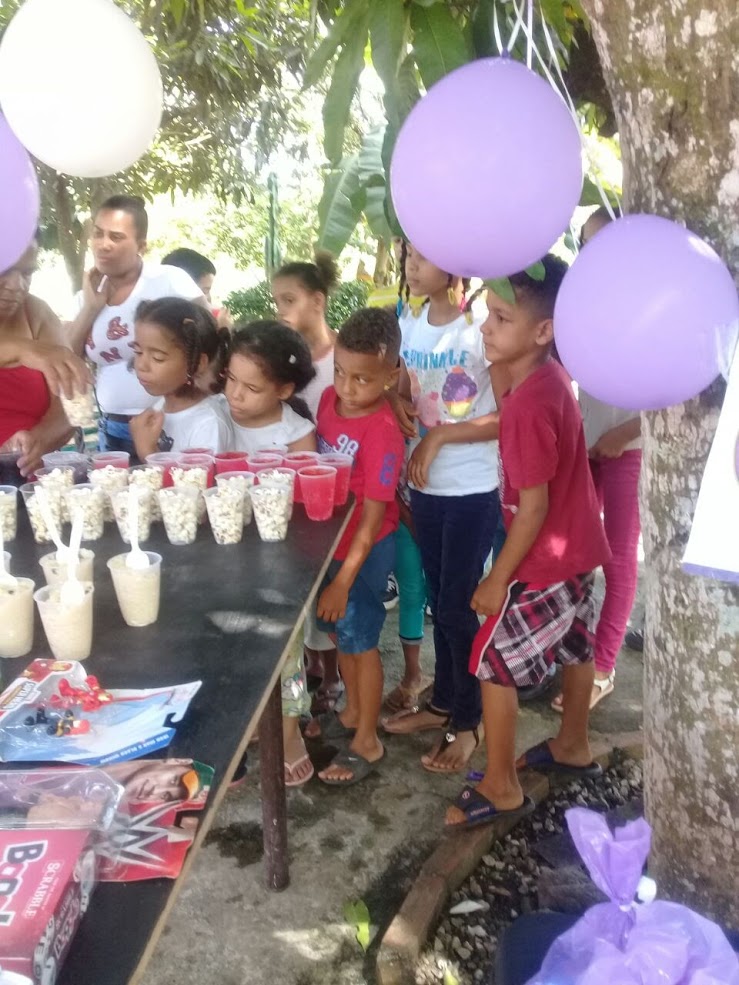 Children forming a line and receiving snacks and drinks in a cup