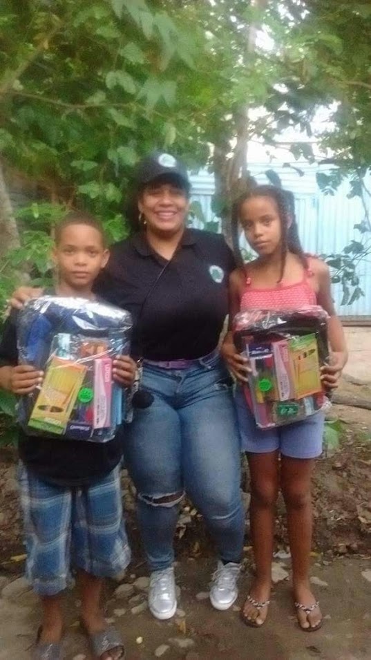Two children receiving bags and school supplies