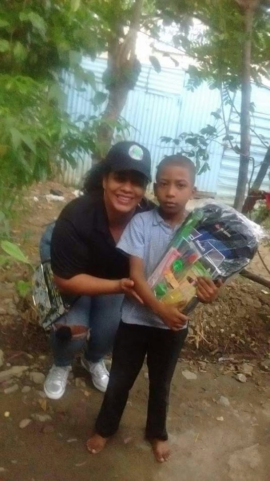 A boy receiving a bag and school supplies