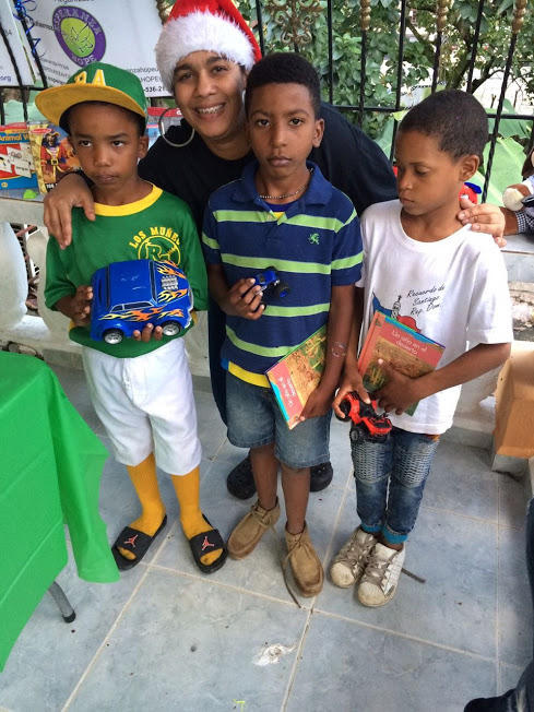 Our staff and three boys holding toy cars and books; window at the back