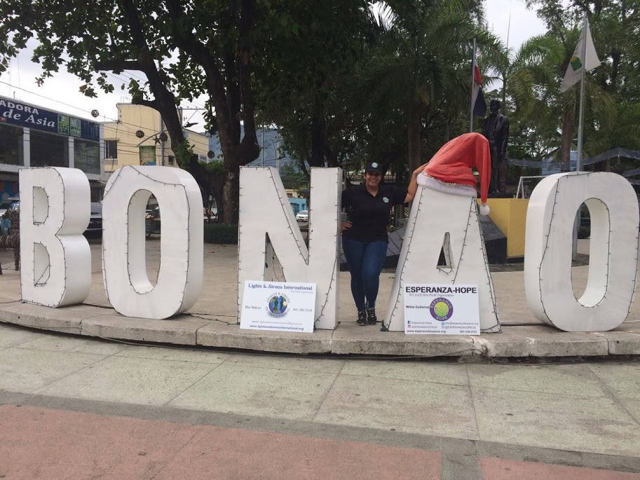 A female staff standing with the BONAO letters, close-