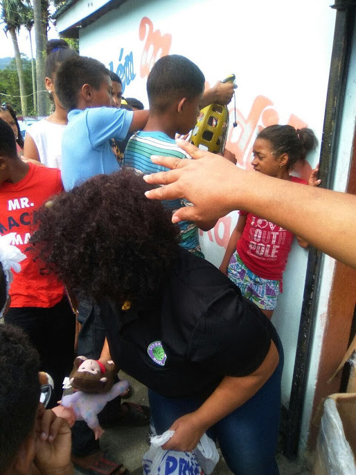 A woman giving toys and children at the back