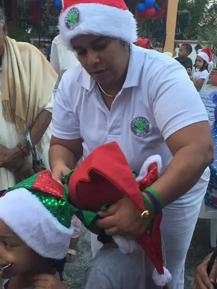 One of our female staff putting a Santa hat on a child