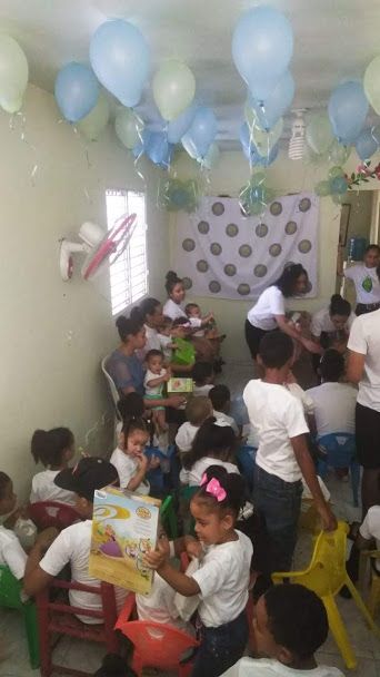 A small room full of children and balloons at the ceiling