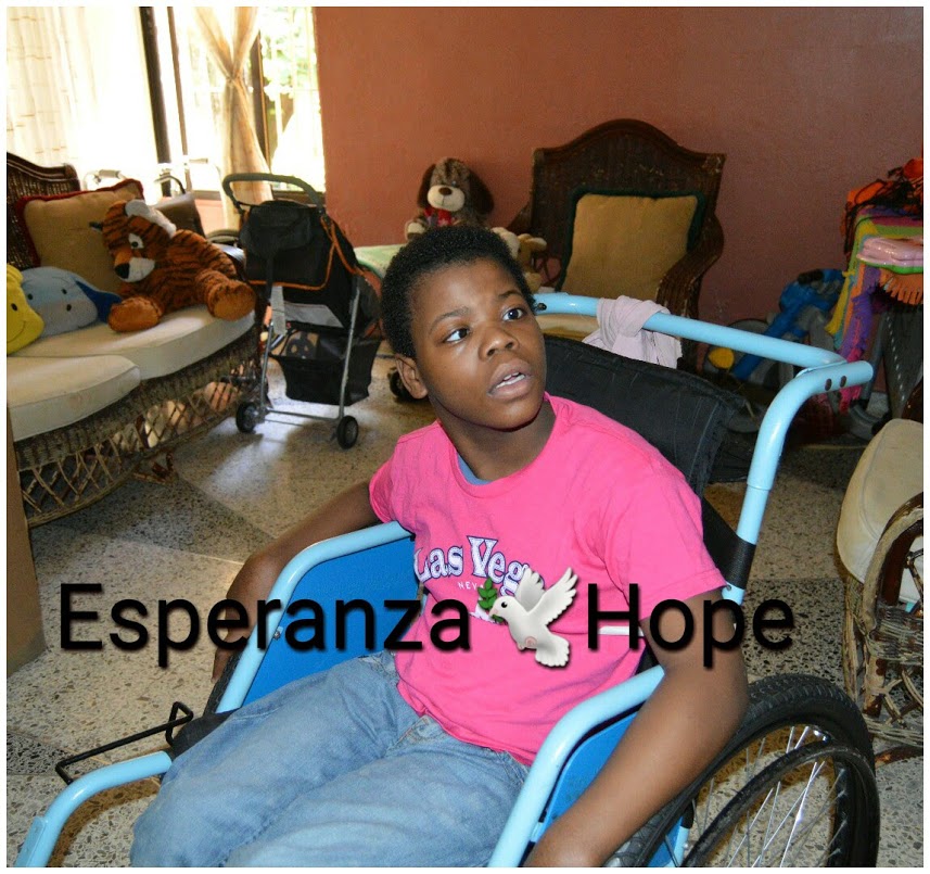 A boy in a wheelchair in a pink shirt. Text: Esperanza-Hope