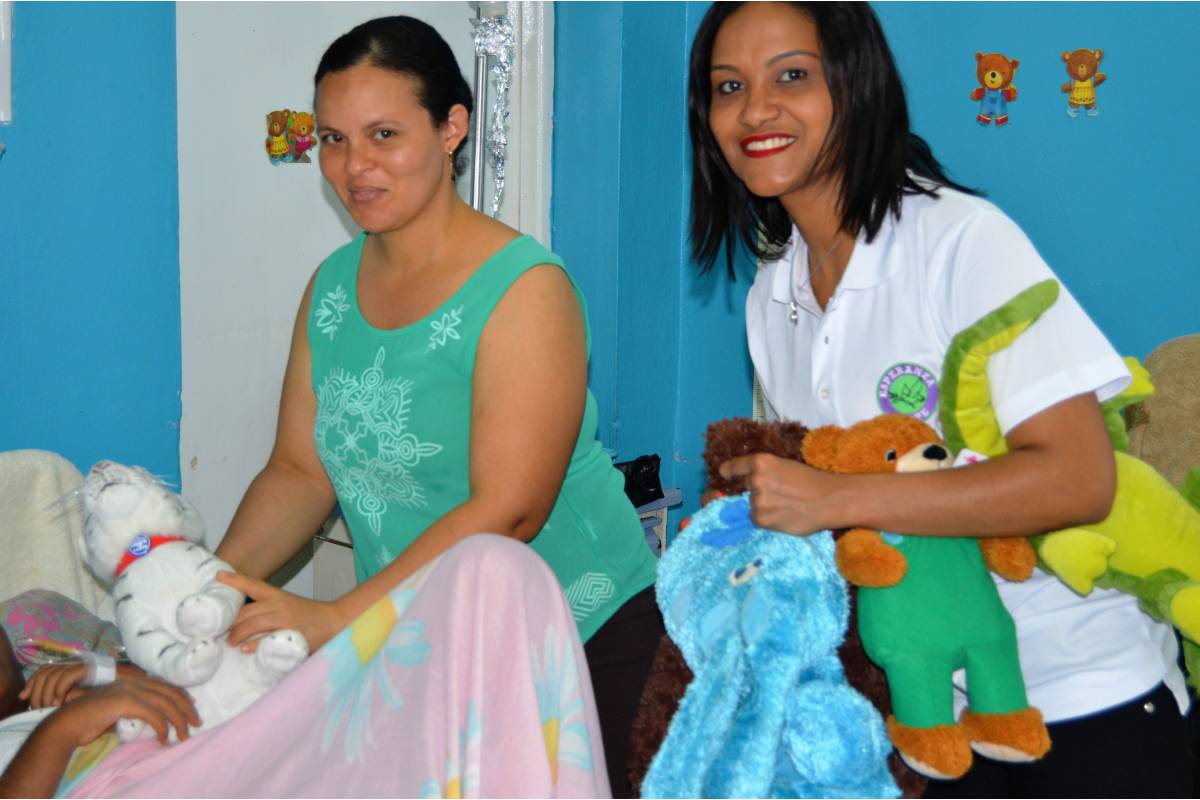 Our staff carrying stuffed toys and a woman standing by a hospital bed