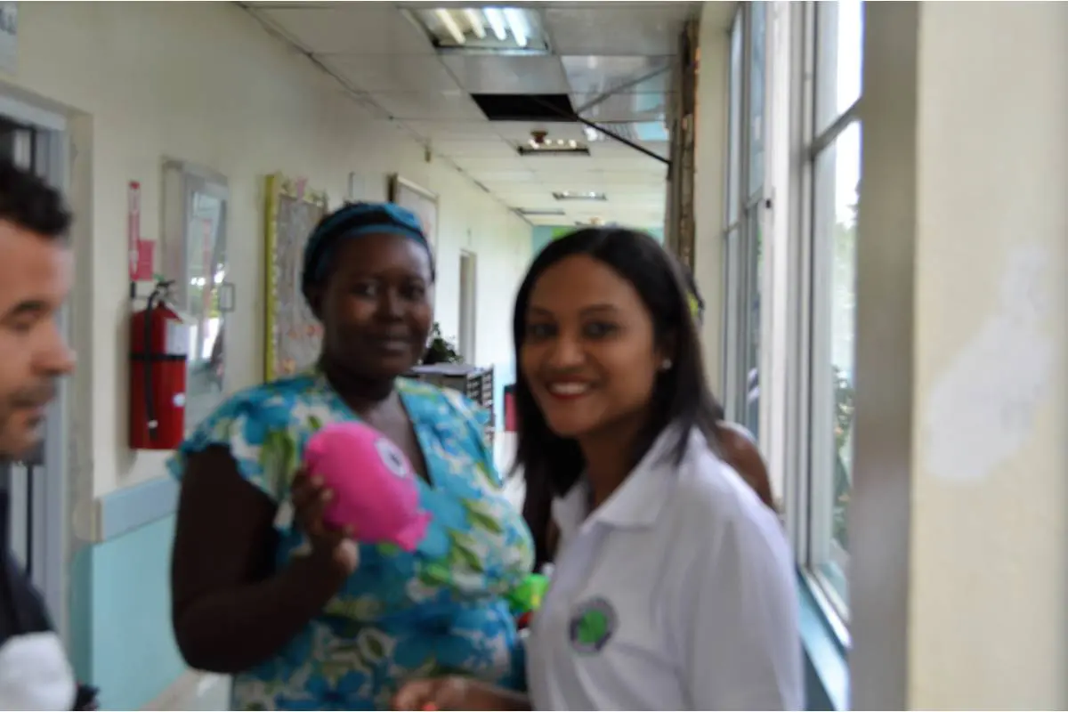 Our staff and a woman holding a toy in the hospital corridor