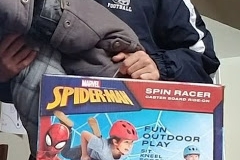 Cropped, a person carrying a Spiderman spin racer box
