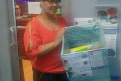 A woman showing a blue box with something colorful inside