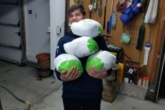 A boy holding four bags of turkey, different angle