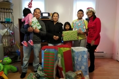Our staff with a family of five, holding gifts