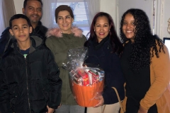 Five people with one of them holding an orange basket of groceries