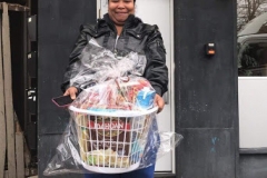 A woman carrying a basket of groceries, cropped