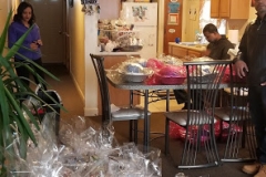 A kitchen with many bags of turkey on the table