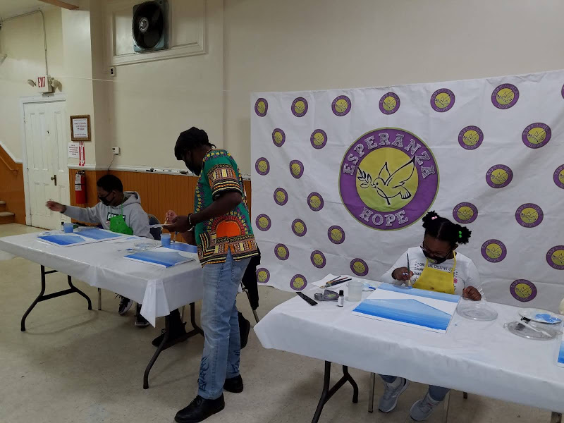 A man in colorful shirt looking at one of the participant’s painting