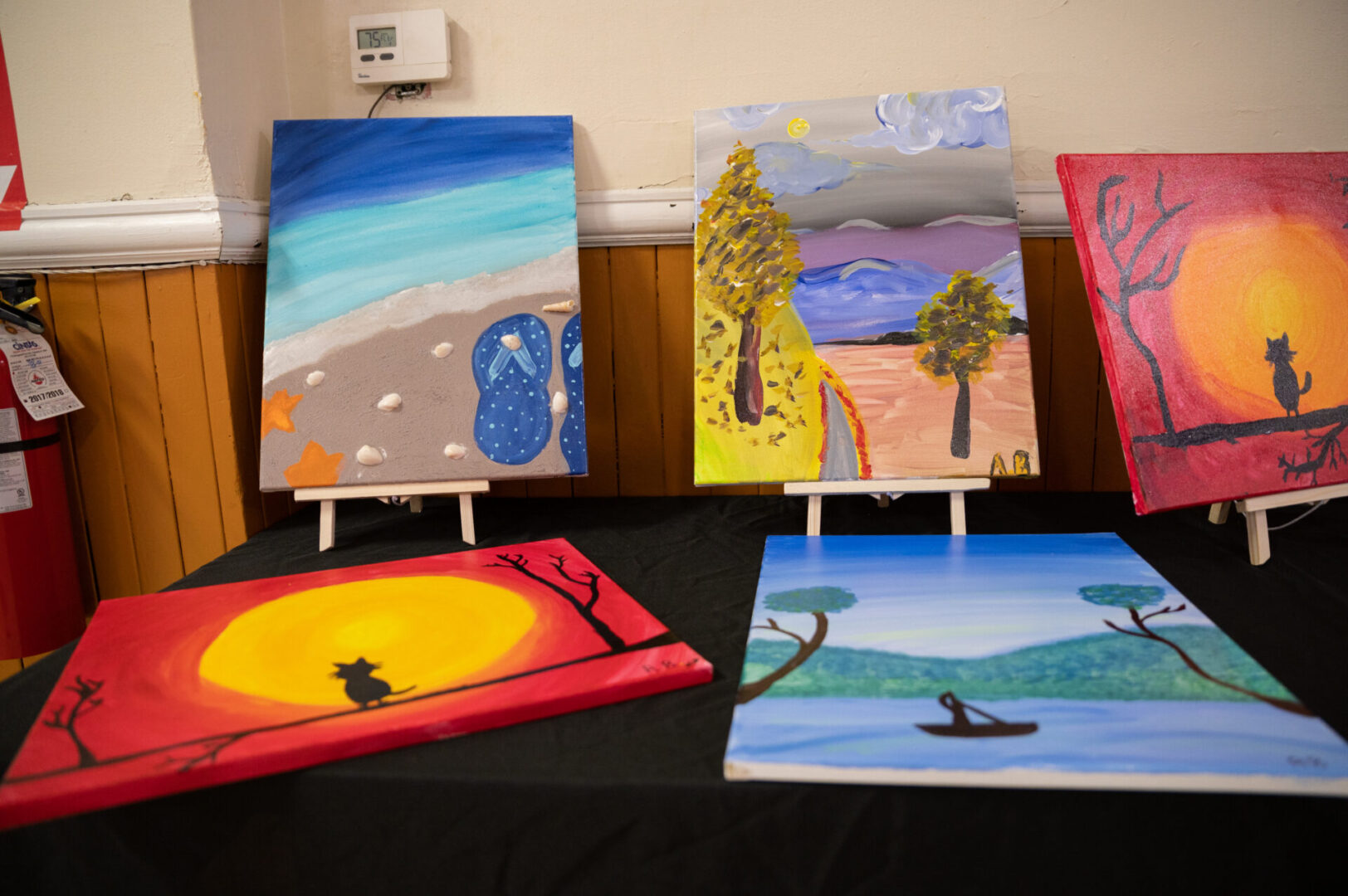 Seashore and slippers painting and two trees on a road to a mountain painting
