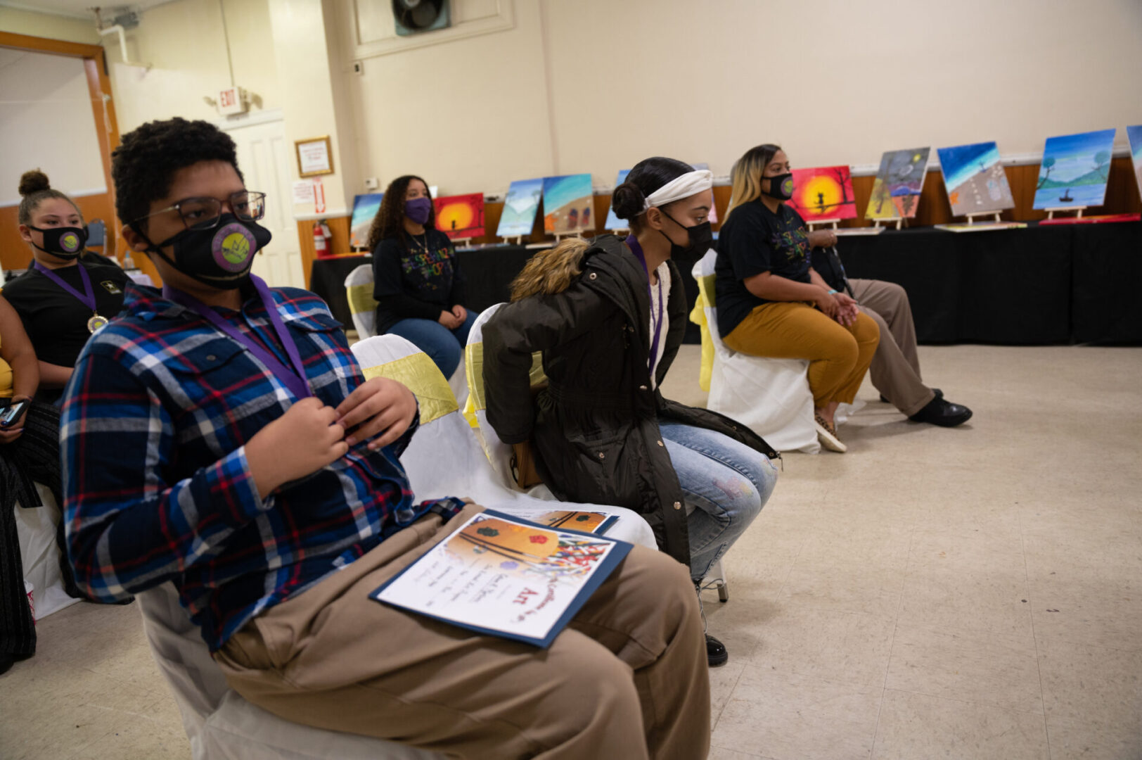Attendees wearing masks and sitting on their chairs