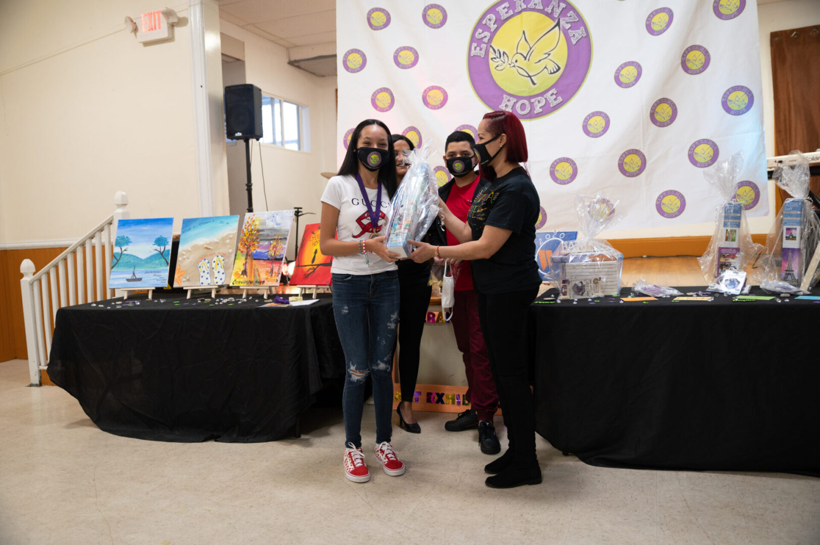 Another girl wearing a medal receiving a box of Artist’s Loft product