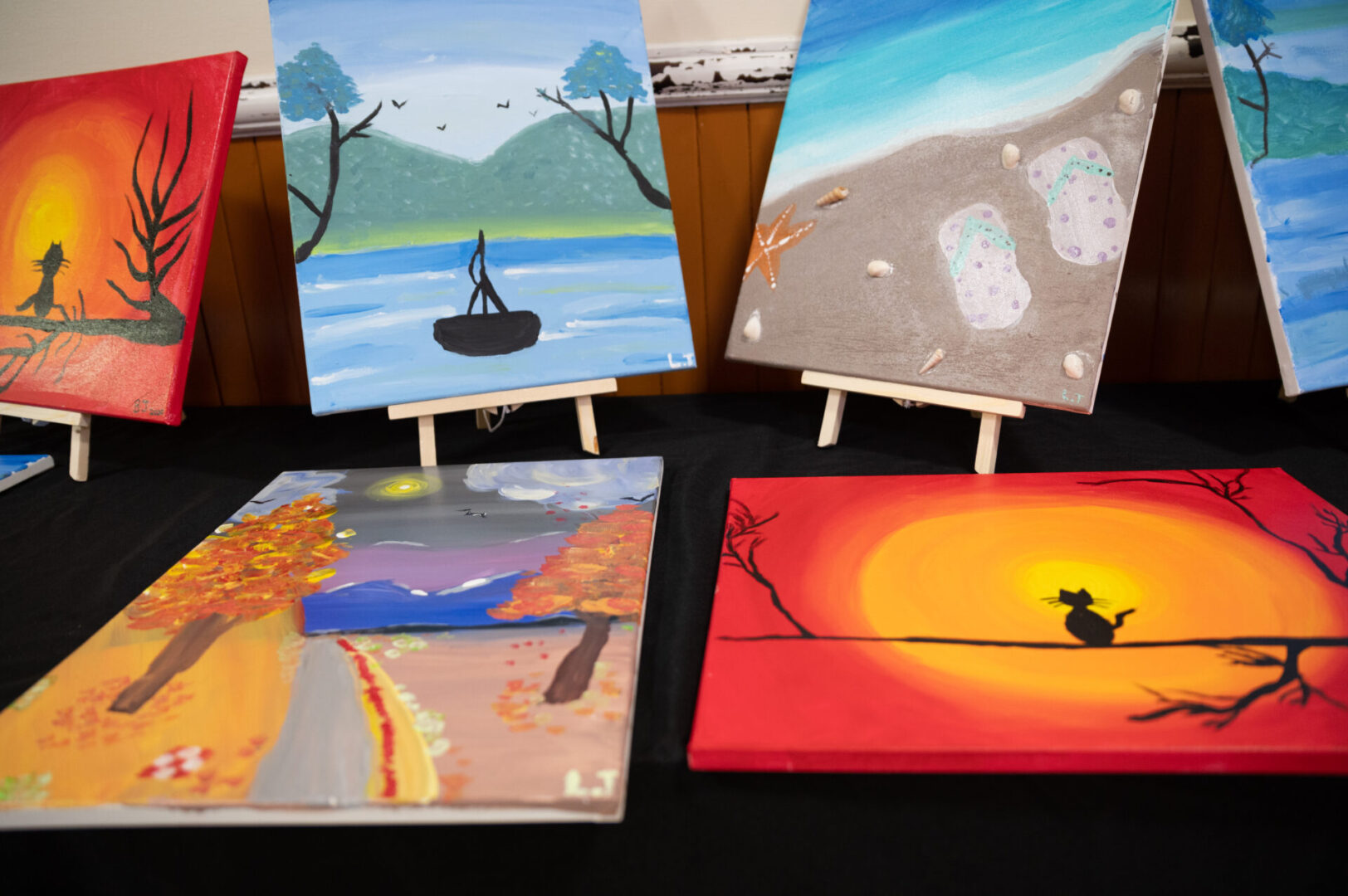 Six paintings displayed on the table