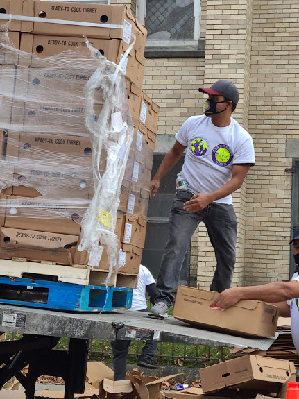 A male staff standing at a truck with stacks of boxes