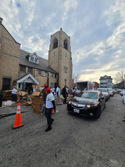 Cars pass by as our staff continue to carry boxes to the church