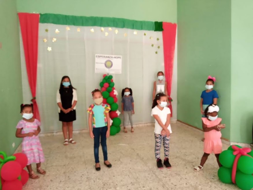 A group of little girls wearing masks, standing in the front
