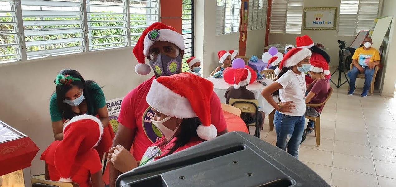 Two of our staff wearing Santa hats and masks