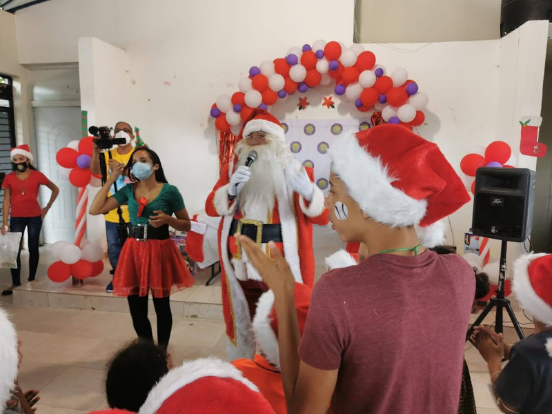 Santa Claus and the elf in front of the children