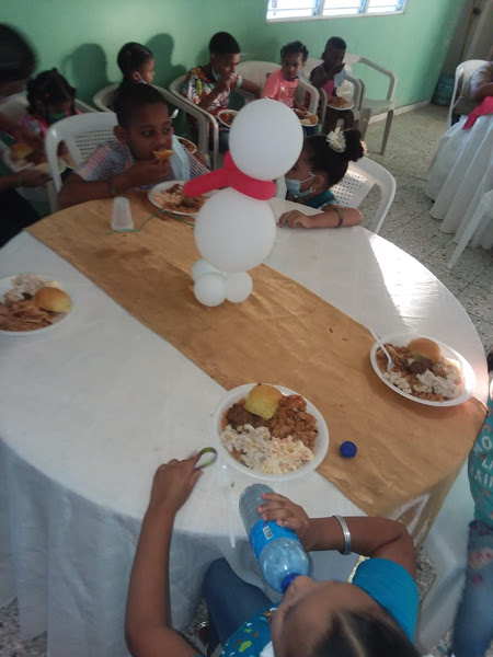 Children eating at a table with a snowman balloon