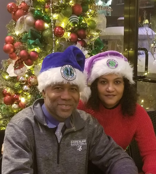 A man and a woman wearing Santa hats with Esperanza-Hope’s logo