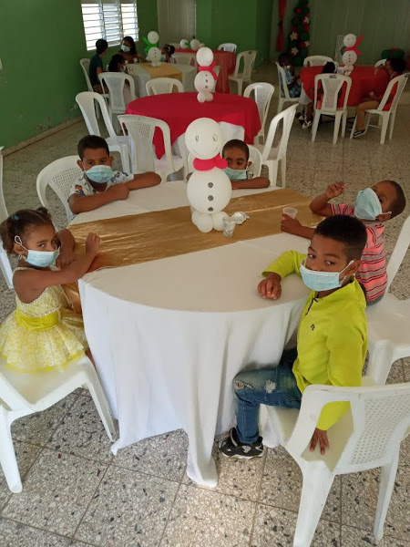 Children seating at a table with a snowman balloon