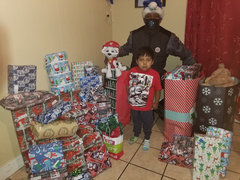 A man and a child surrounded by many Christmas gifts