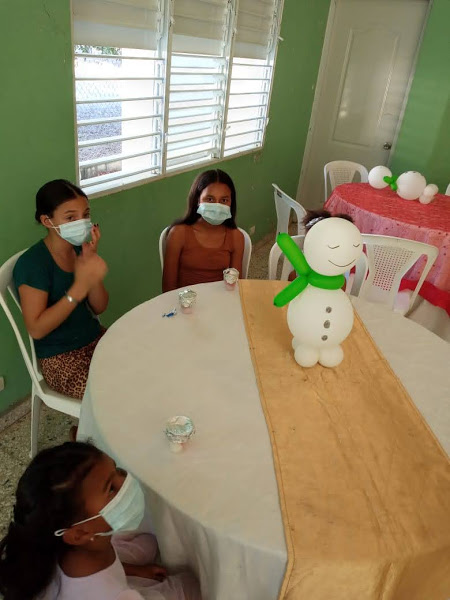 Girls sitting at a table wearing masks