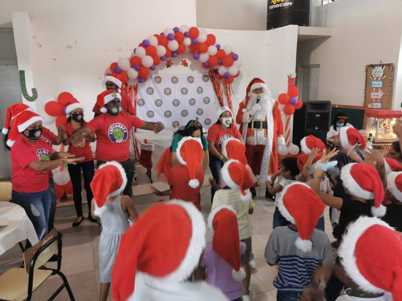 Children and staff all wearing Santa hats and standing up for a game