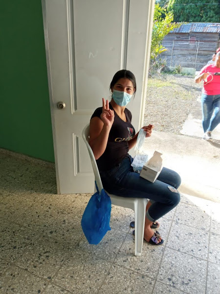 A woman wearing mask sitting in chair near an open door