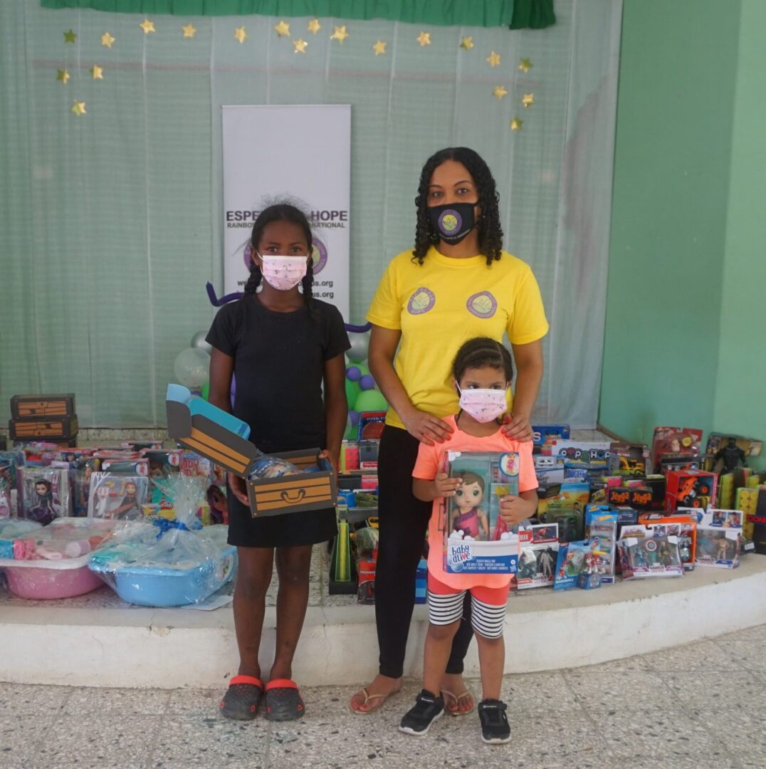 Our staff standing with two girls holding their toys