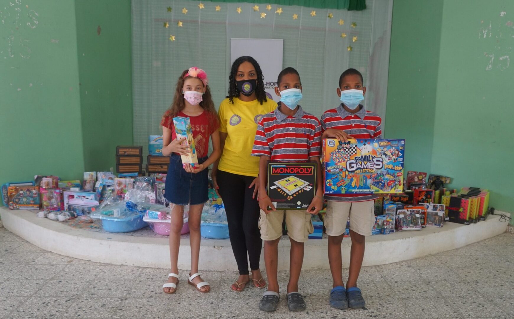 Our staff, a girl, and twin boys, the children holding boxes of toys