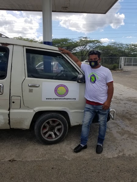 A male staff posing in front of our organization’s van
