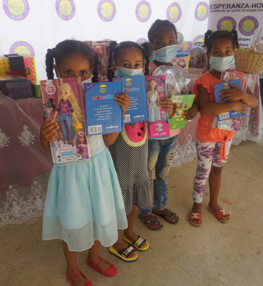 Four young girls wearing masks and holding books and toys, batch 2