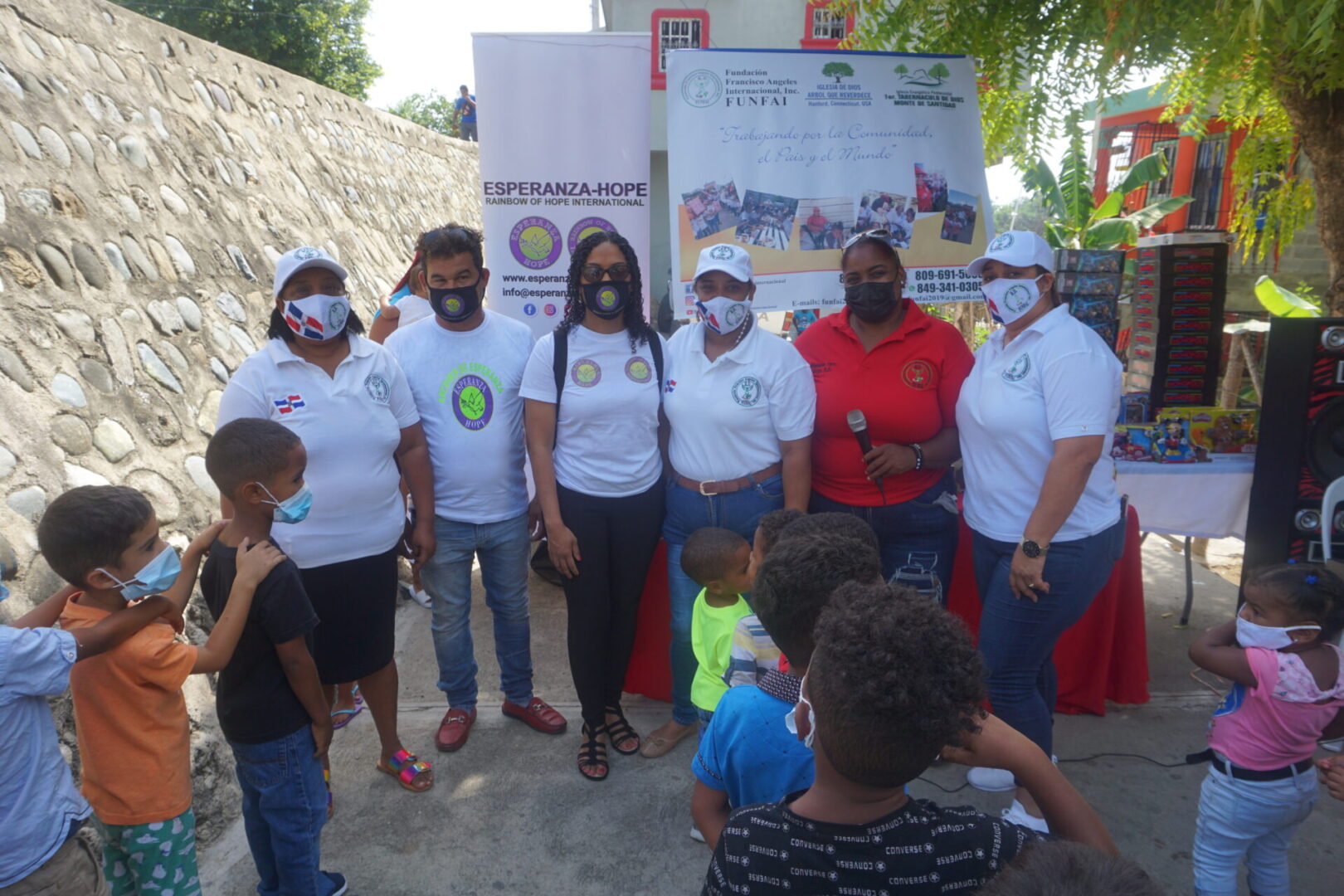 Six of our staff wearing masks, standing in front of the children in line