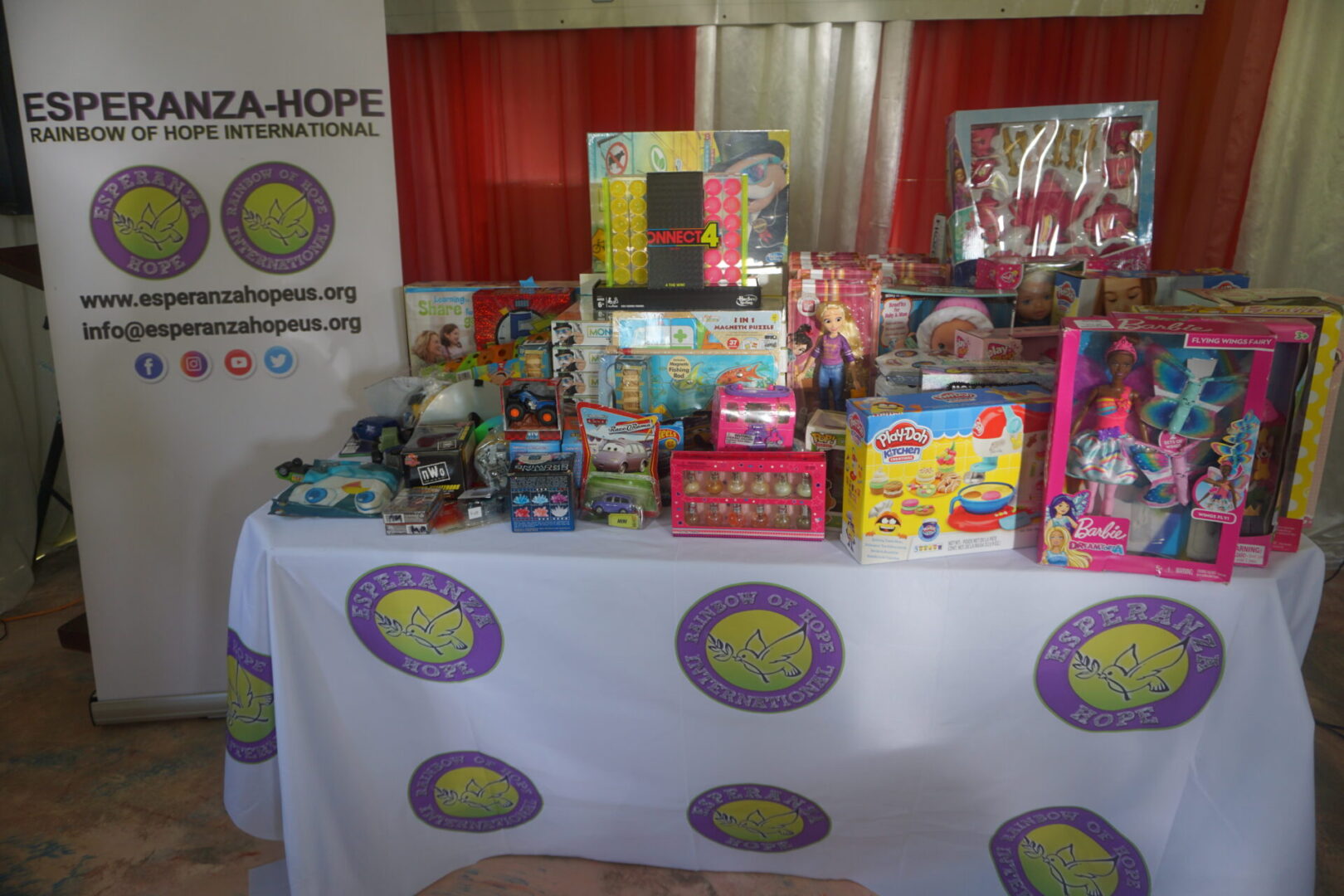 A table with Esperanza-Hope logos full of toys