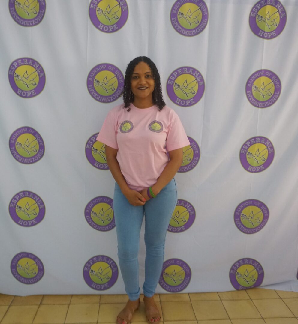 A woman in pink shirt standing against the Esperanza-Hope backdrop