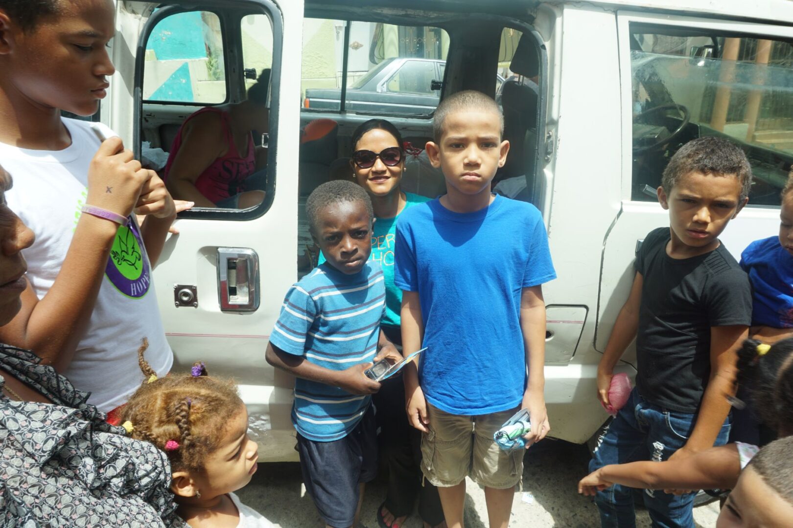 Two boys wearing a blue shirt and holding toys, our staff at the back